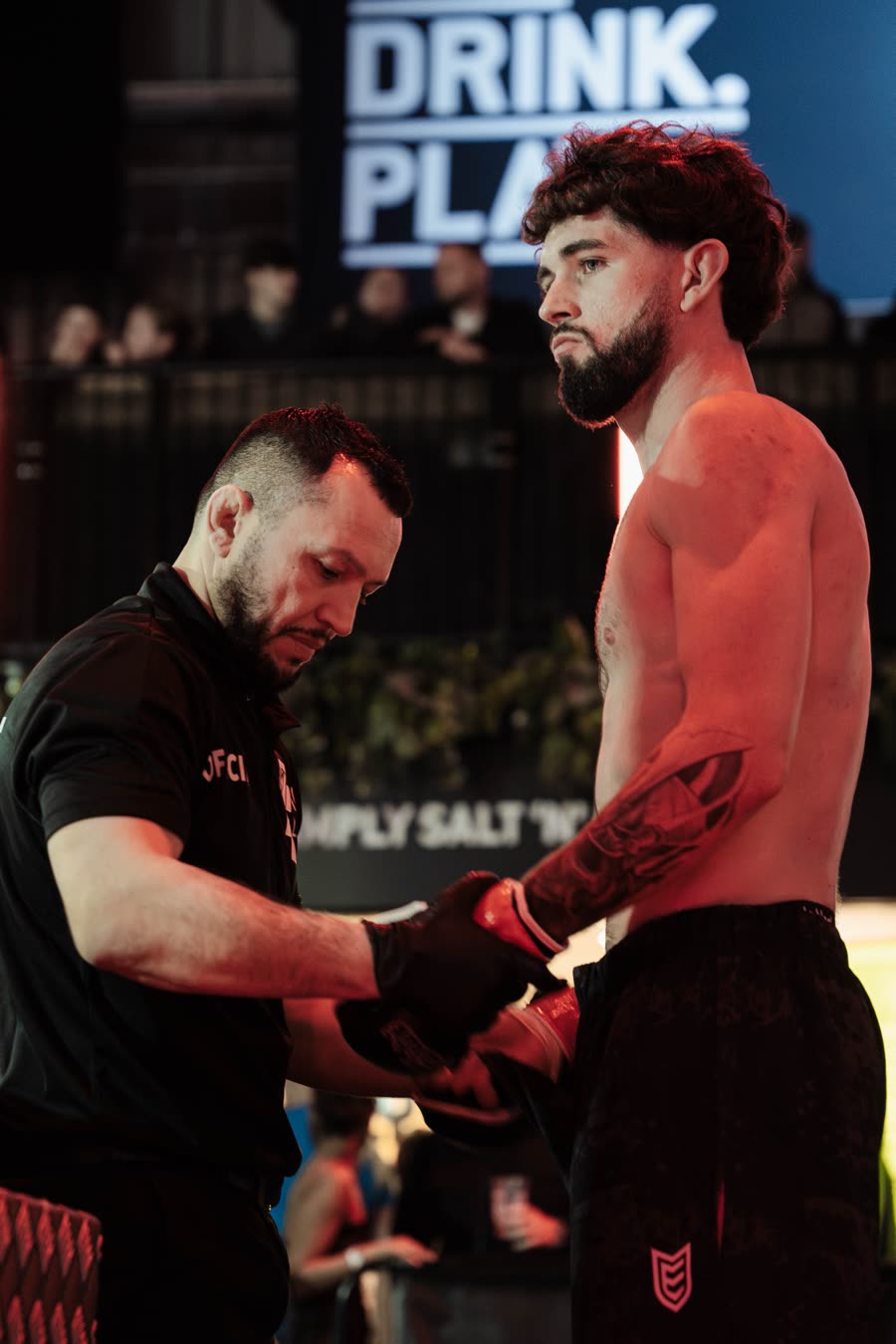 An official checking the gloves in the cage before the fight