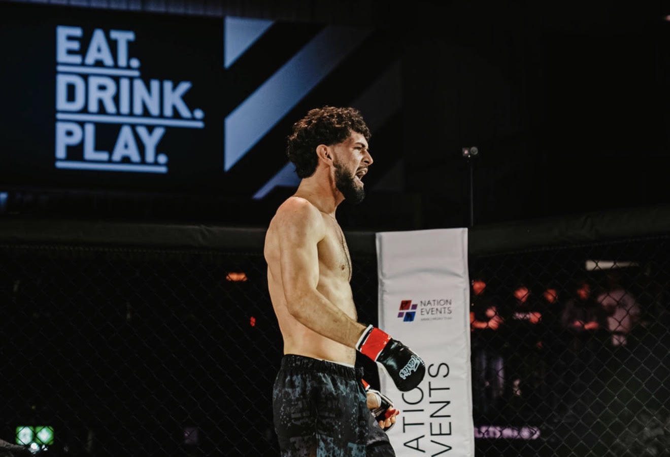 A Two More Mission fighter in the cage under the arena lights