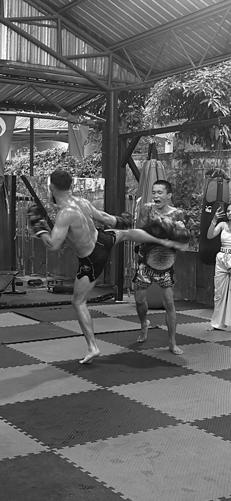 Training Muay Thai pads at an open-air gym in Thailand